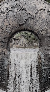 Water flowing through a hole in a giant eye-like sculpture by Mark Quinn entitled 'All of Nature Flows Through Us' (2011) Photograph of an eye-like sculpture and water